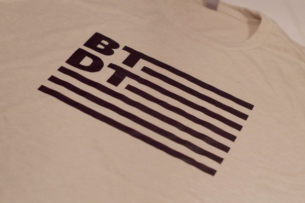 Tan BTDT men's T-shirt, with our flag logo across entire chest. Let others know you've been there, done that!